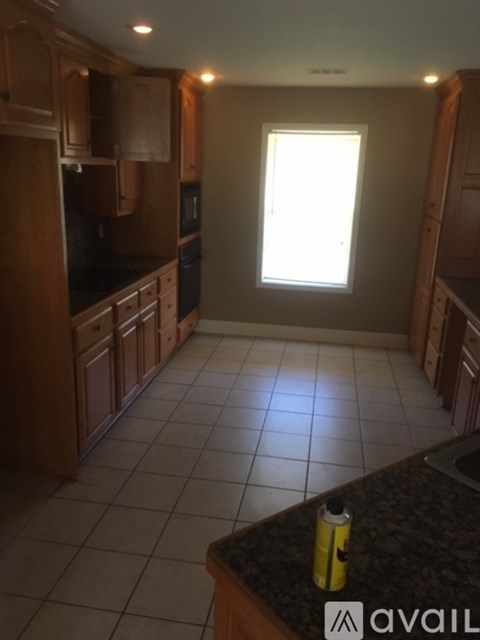 A kitchen with wooden cabinets and a black countertop.