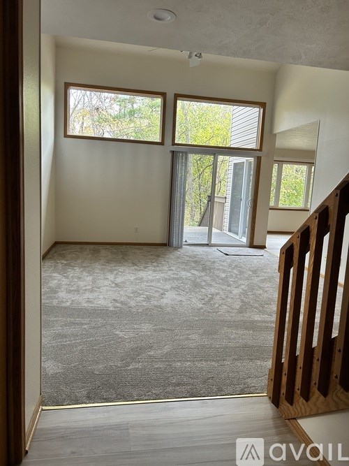 A room with a large window and sliding glass doors.