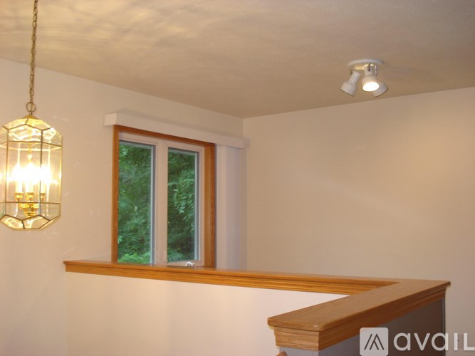 A room with a window and a light hanging from the ceiling.