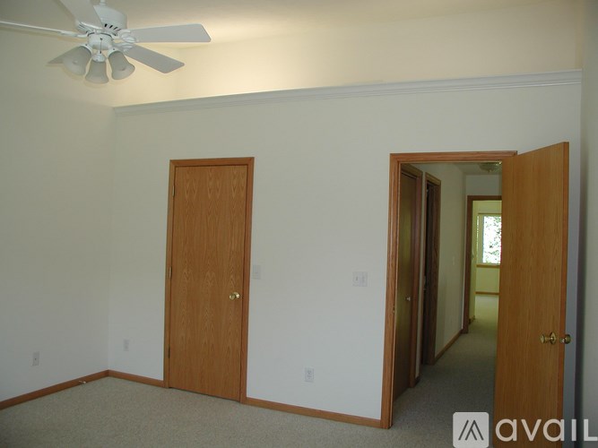 A room with a ceiling fan and two doors.