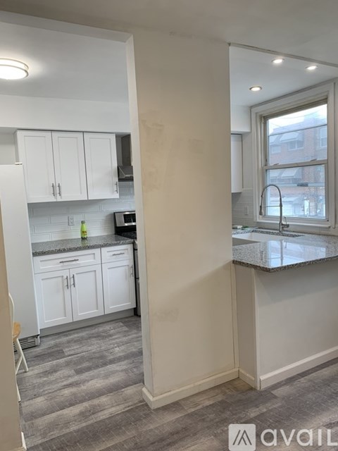 A kitchen with white cabinets and a window.