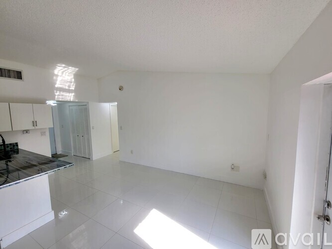 A spacious, empty room with white walls and a tiled floor.