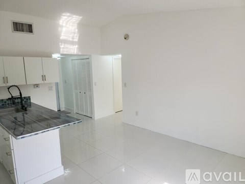 A kitchen with white cabinets and a granite countertop.