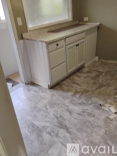 A bathroom with a marble floor and a window.