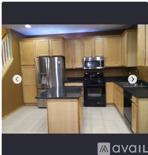 A kitchen with wooden cabinets and a black countertop.