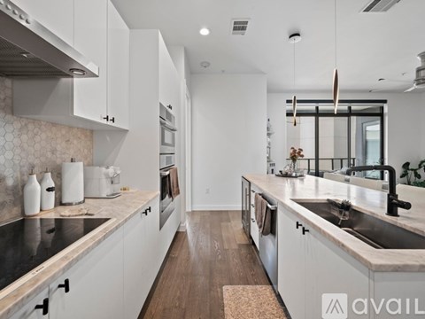 A modern kitchen with white cabinets and a black countertop.