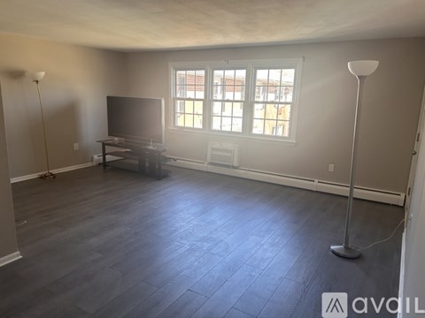 A living room with a television and a window.