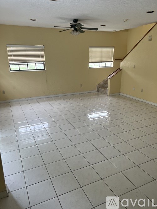 A living room with a fan and a staircase.