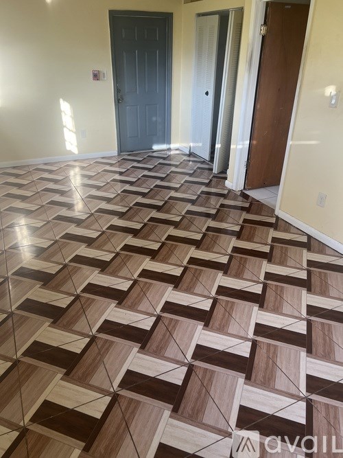 A hallway with a tile floor and a door on the left.