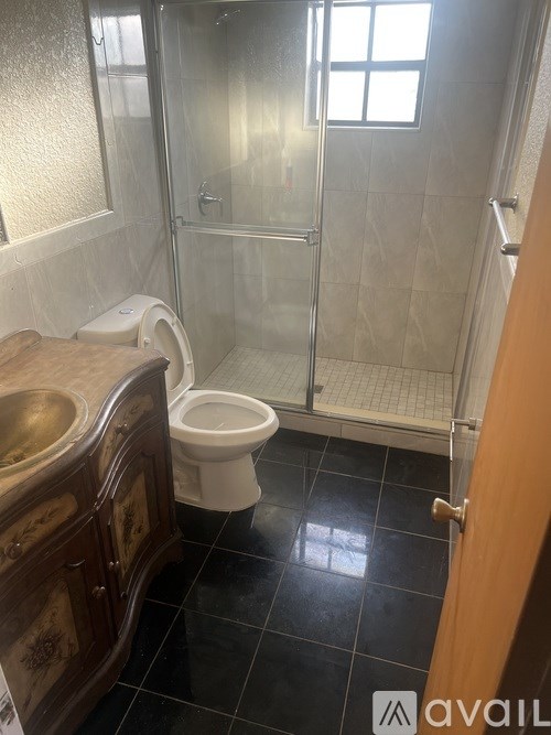 A bathroom with a toilet, sink, and walk-in shower.