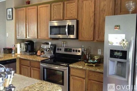 A kitchen with wooden cabinets and granite countertops.