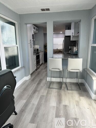 A kitchen with a dining table and chairs in the middle of the room.