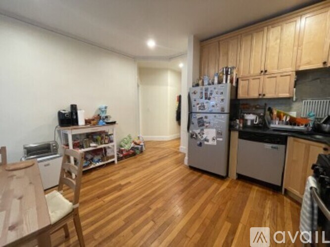 A kitchen with wooden floors and a refrigerator.