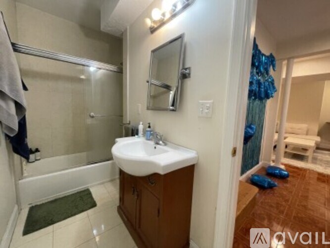 A bathroom with a white sink and a glass shower stall.
