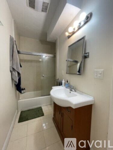 A bathroom with a sink, mirror, and a towel hanging on the wall.
