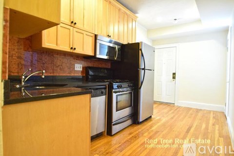 A kitchen with wooden cabinets and black appliances.