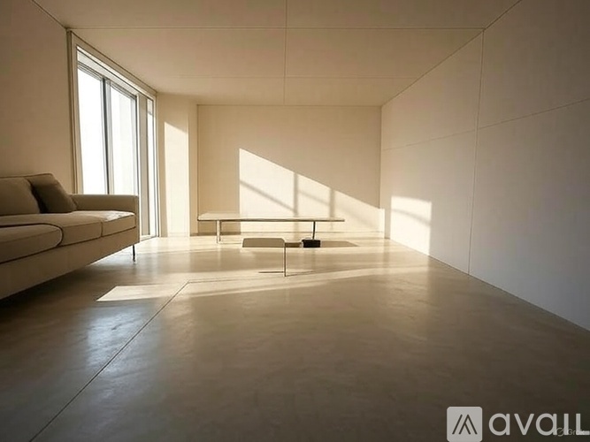 A modern living room with a couch, a chair, and a large window.
