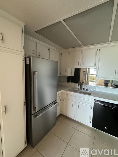 A kitchen with a refrigerator and a dishwasher.