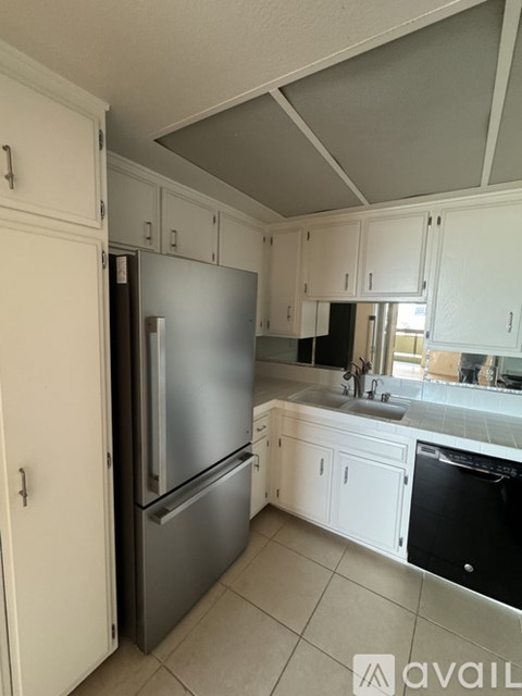 A kitchen with a refrigerator and a dishwasher.
