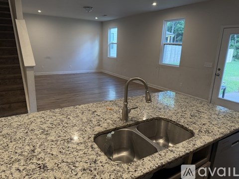 A kitchen with granite countertops and a double sink.