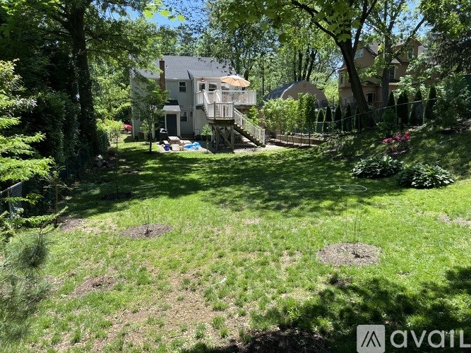 A house with a deck and a tree in front of it.