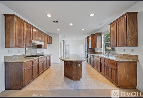 A kitchen with wooden cabinets and a central island.