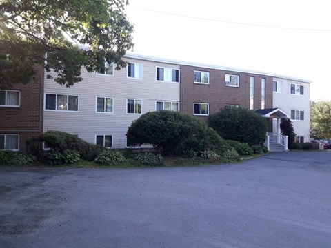 A large building with a parking lot in front.
