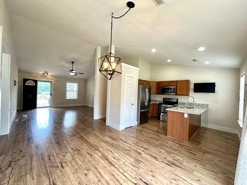 A kitchen with a refrigerator, microwave, and oven is visible.