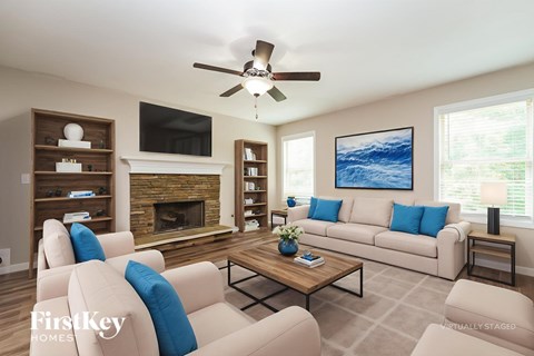 A living room with a fireplace and a painting on the wall.