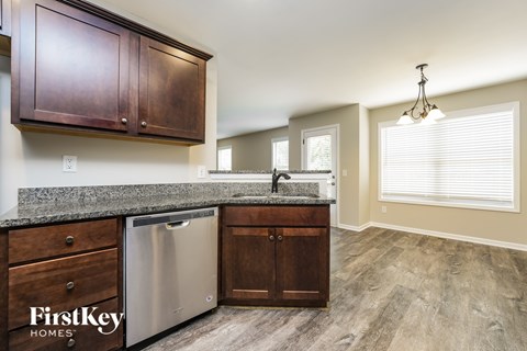 A kitchen with wooden cabinets and a stainless steel dishwasher.