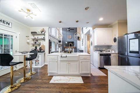 A kitchen with white cabinets and a black fridge.