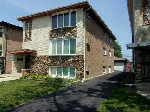 A long brick building with a stone pillar in the middle of it.