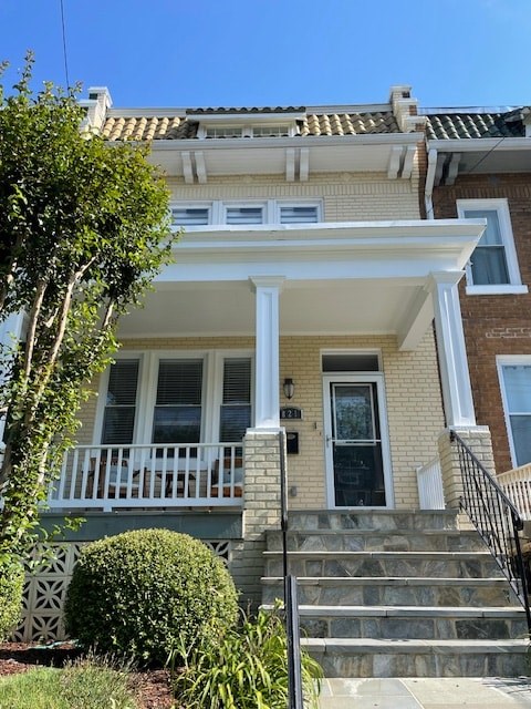 A house with a white porch and a black staircase.