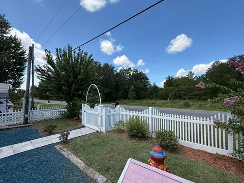 A white picket fence surrounds a pool with a slide.