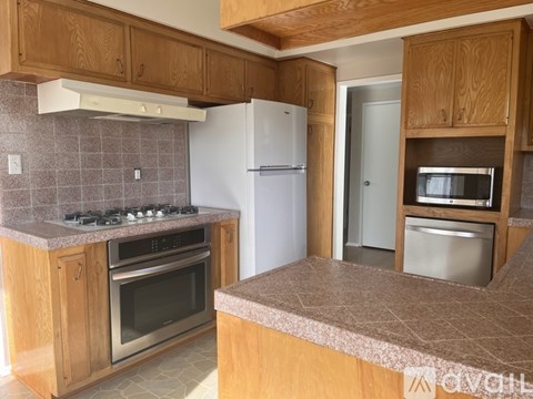 A kitchen with wooden cabinets and a white refrigerator.