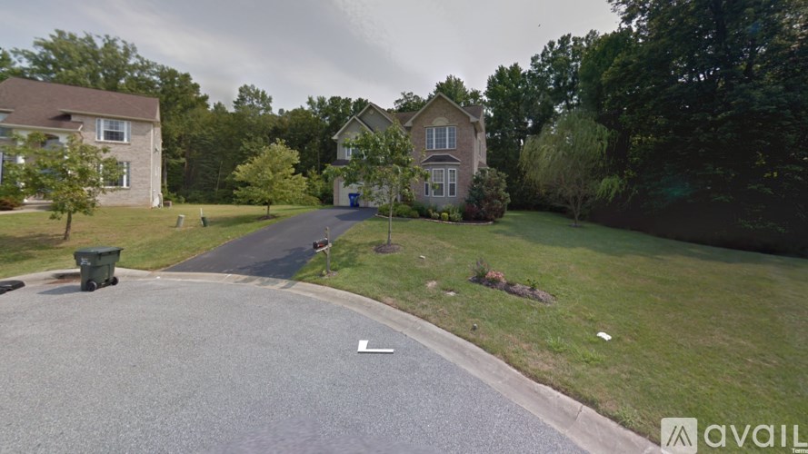 A street view of a residential area with houses and trees.