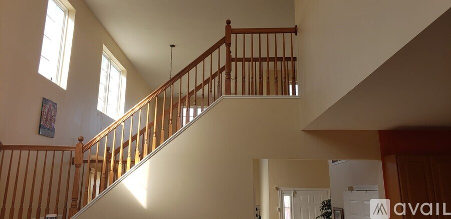A staircase with a wooden railing and a light brown carpet.