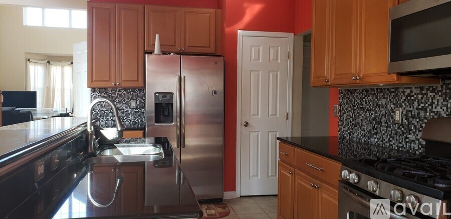 A kitchen with a stove top oven and a refrigerator.