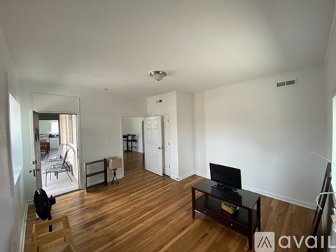 A living room with a television and a wooden floor.