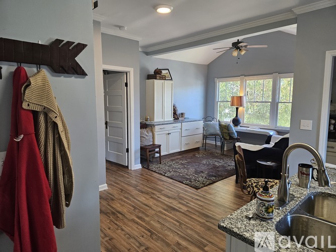 A kitchen with a wooden floor and a ceiling fan.