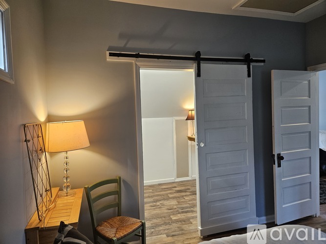 A room with a sliding door and a lamp on a table.