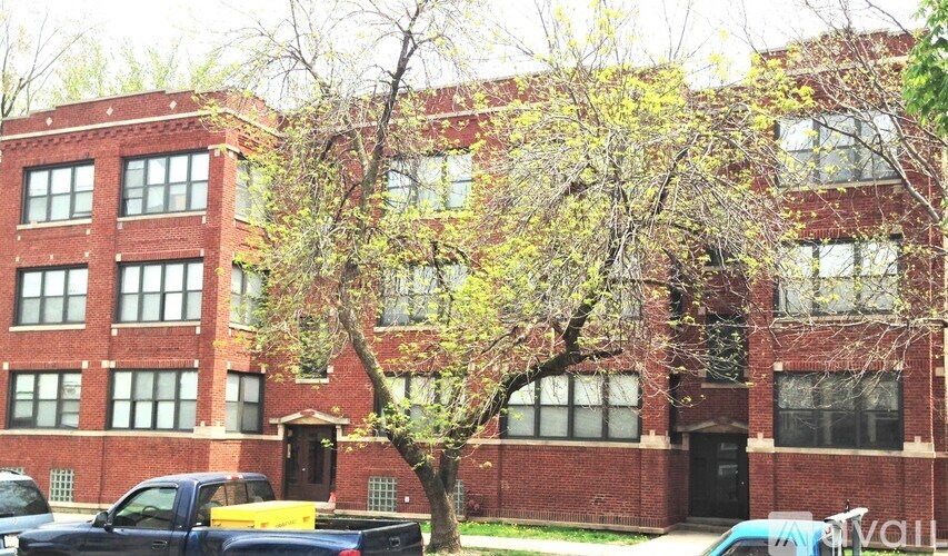 A red brick building with a tree in front of it.