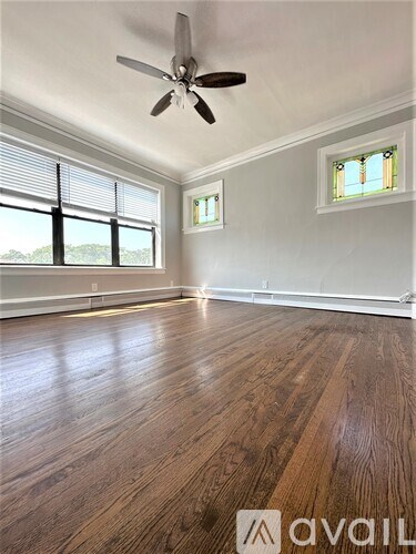A room with wooden floors and a ceiling fan.