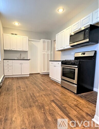 A kitchen with white cabinets and a black stove top oven.