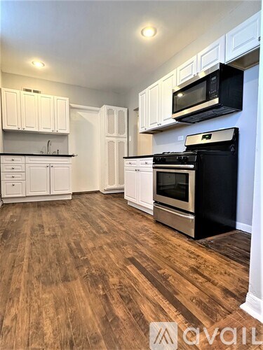 A kitchen with white cabinets and a black stove top oven.