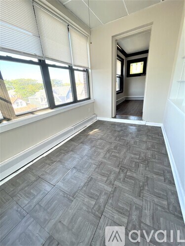 A room with a window and a door leading to another room.