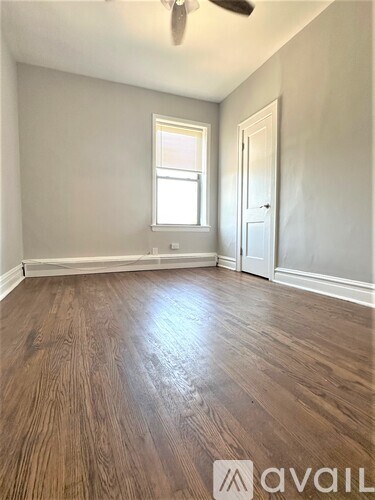 A room with wooden flooring and a window.