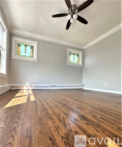 A room with wooden floors and a ceiling fan.