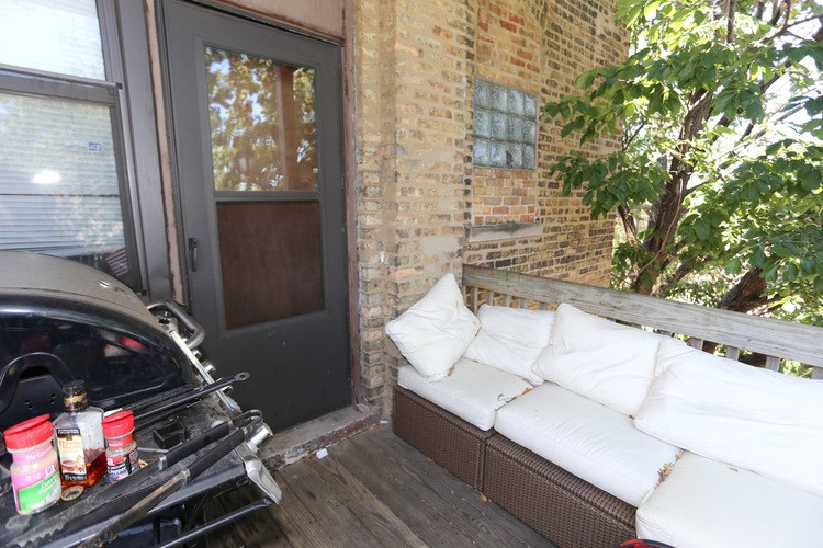 A black car is parked next to a white couch.