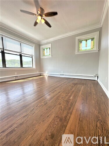 A room with wooden floors and a ceiling fan.